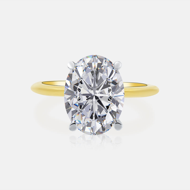 Oval-cut diamond solitaire ring with a yellow gold band and four-prong setting.