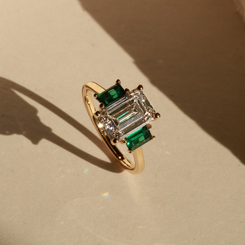 Three Stone Emerald cut diamond and green emerald engagement ring in yellow gold