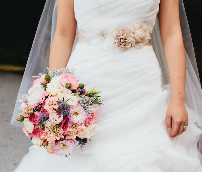 Bridal bouquet with blush flowers and subtle diamond wedding ring.