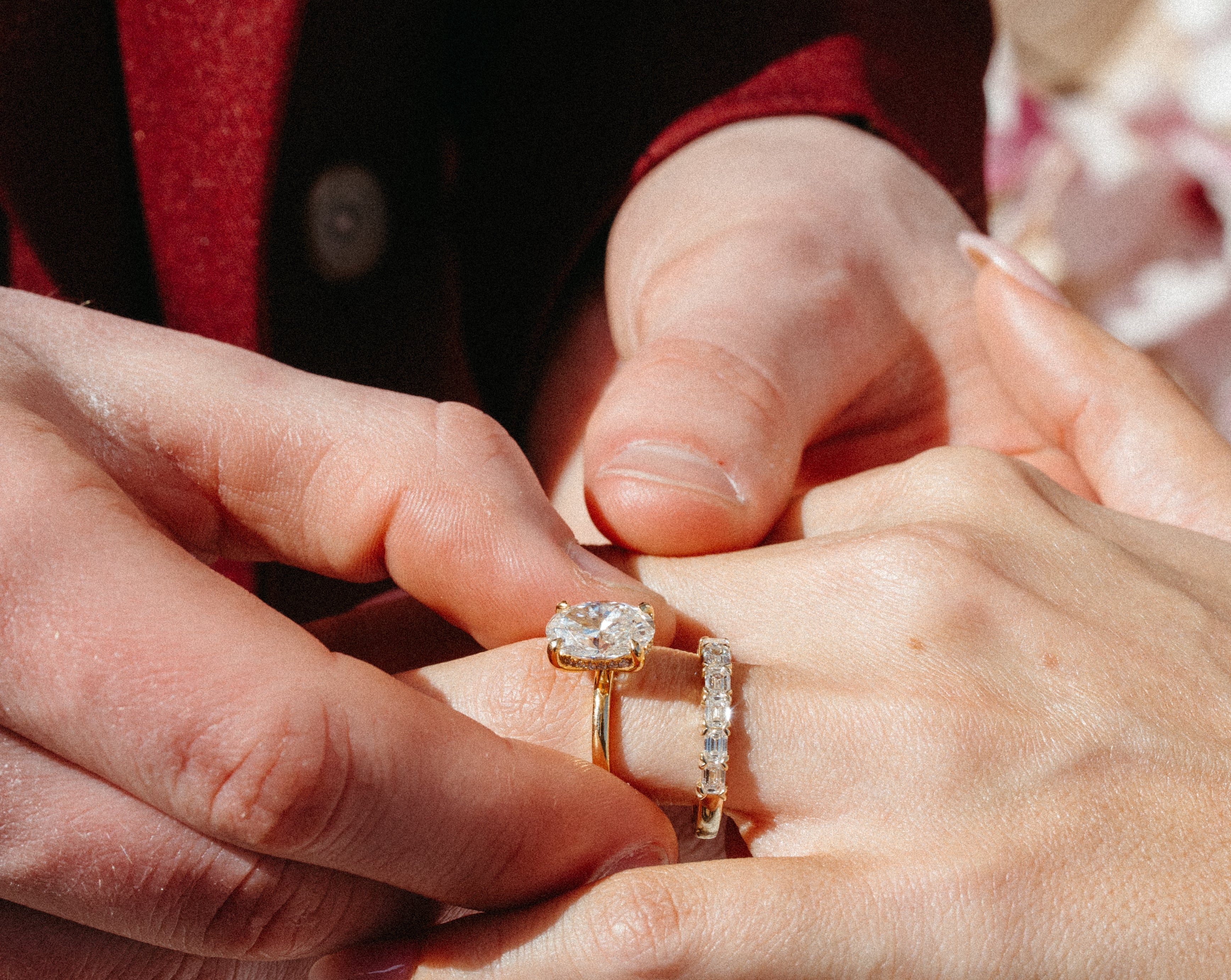 oval diamond solitaire engagement ring with emerald cut band set in yellow gold