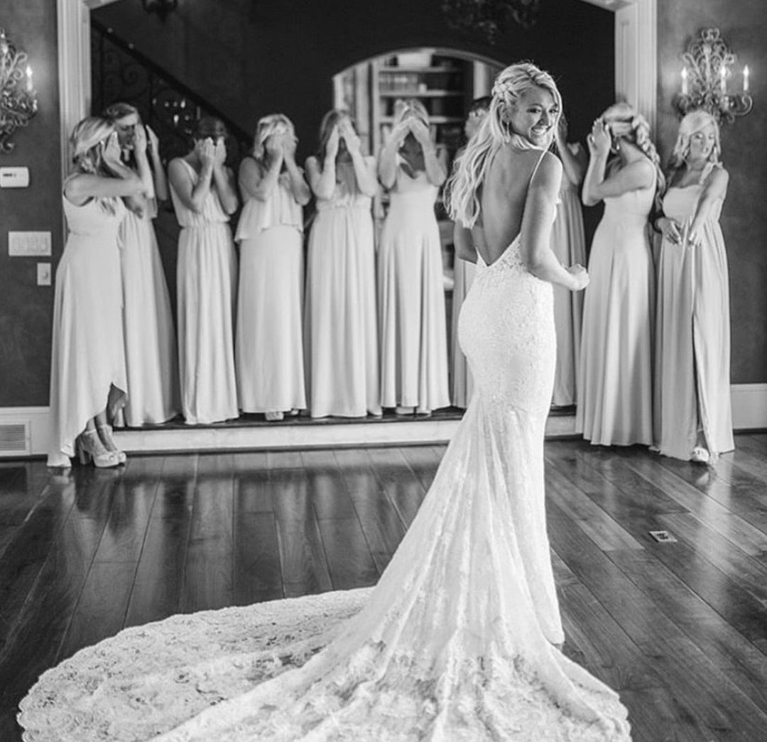 Bride in lace wedding gown with bridesmaids.