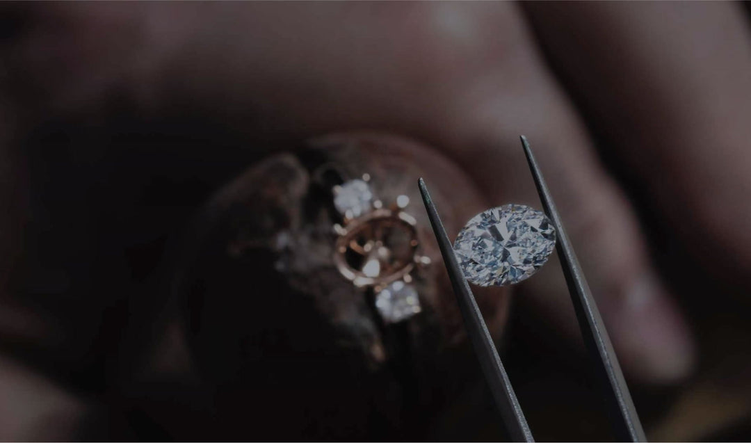 Diamond being held with tweezers, ready to be set in a ring.