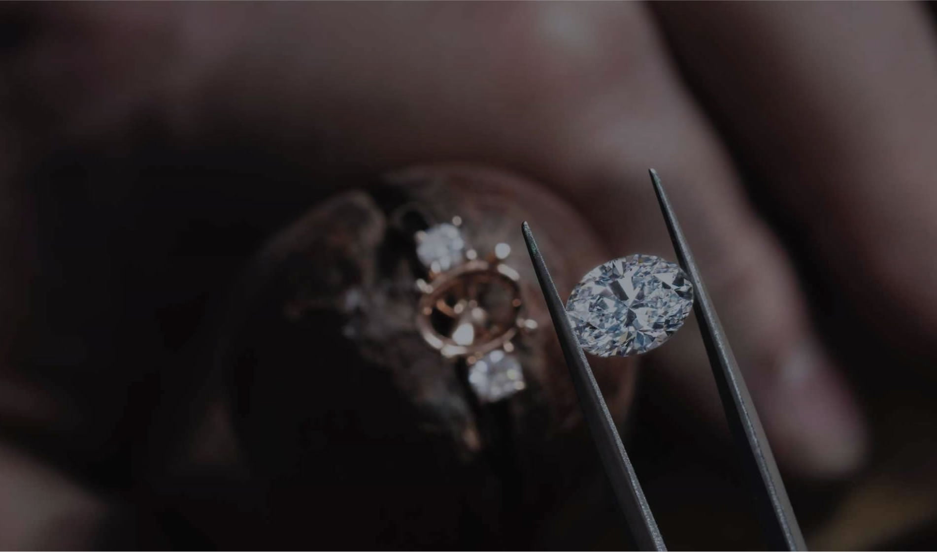 Diamond being held with tweezers, ready to be set in a ring.