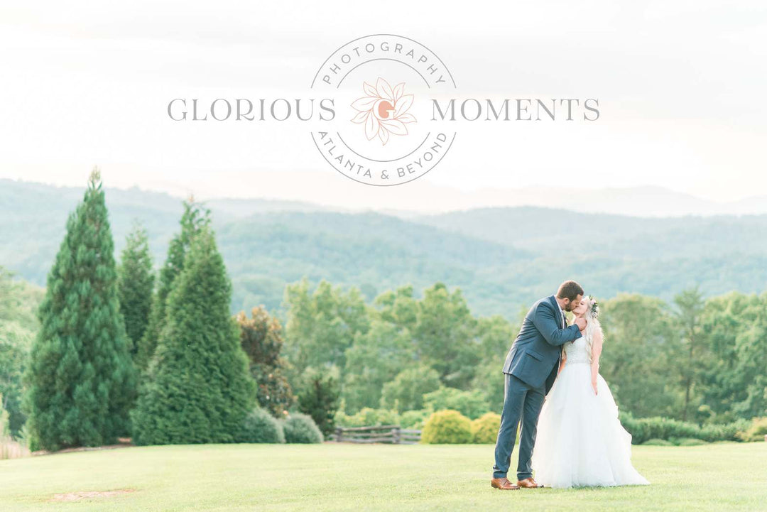 Couple kissing on their wedding day with mountains in the background.