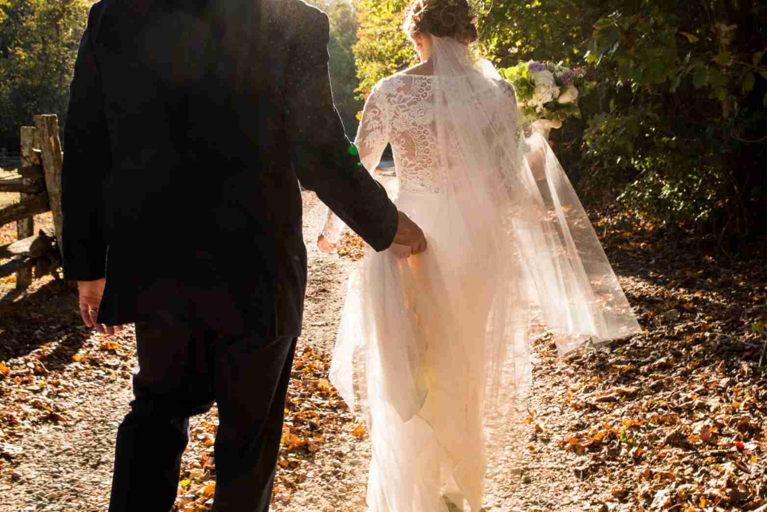 Bride and groom on a nature walk, symbolizing enduring love.