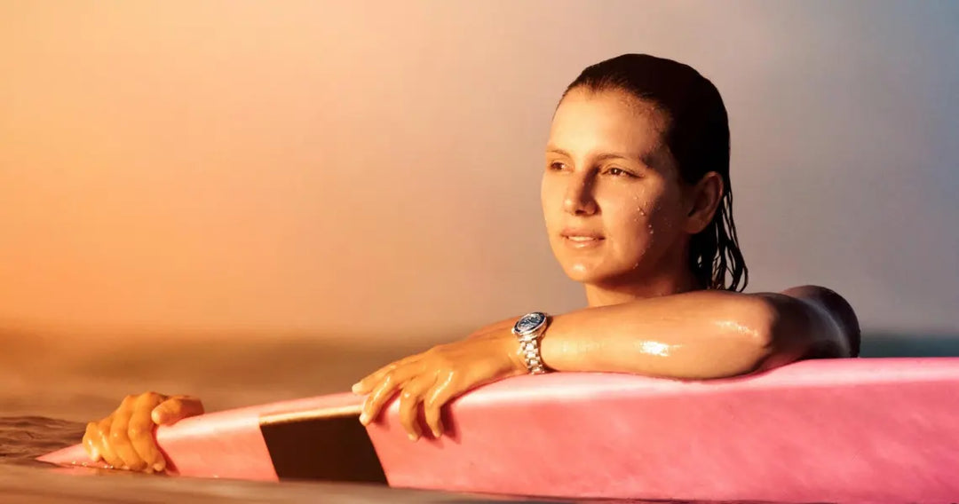 Woman with wristwatch on surfboard.