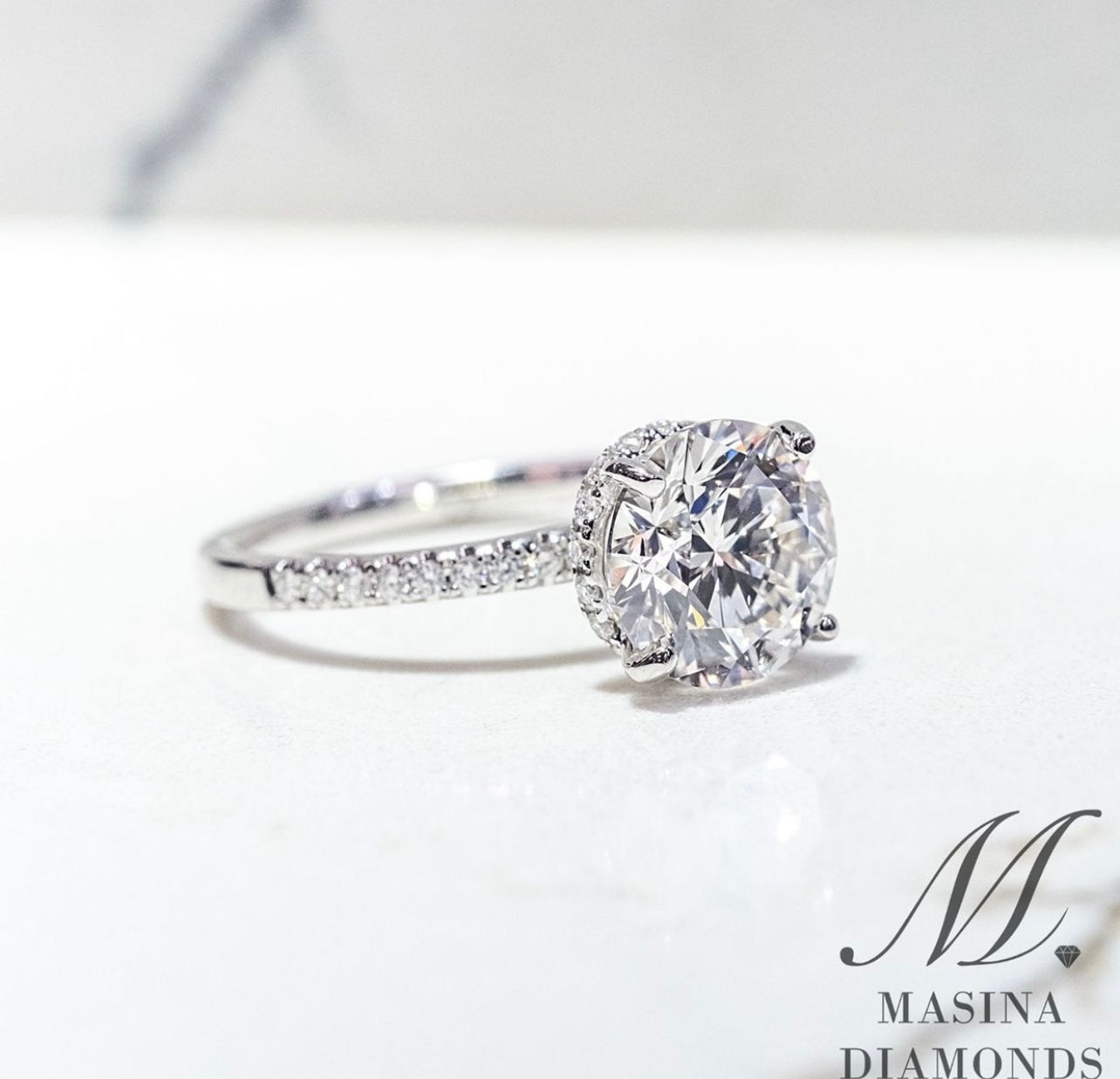 Masina Diamonds hidden halo ring on white marble.