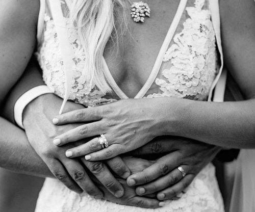 Newlyweds' hands with engagement ring and wedding band.