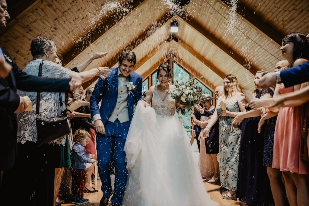 Newlyweds exiting wedding, showered with rice. Budget-friendly celebration tips.