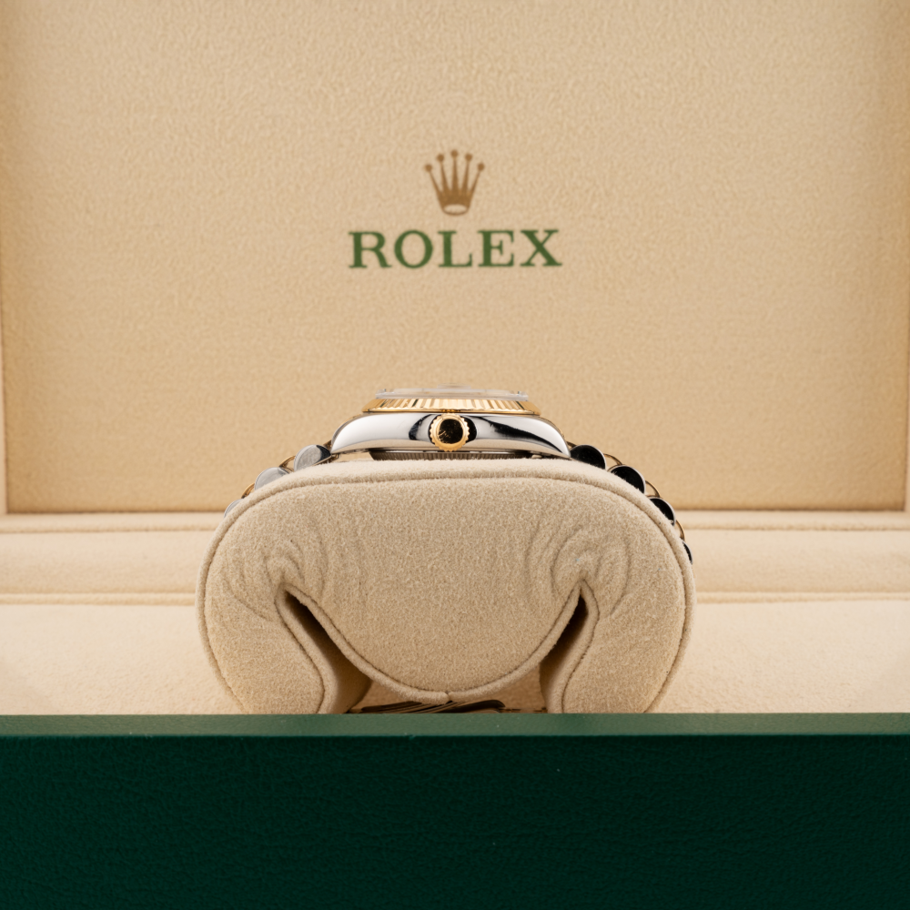 Rolex watch in a cushioned box with the Rolex logo on a beige background