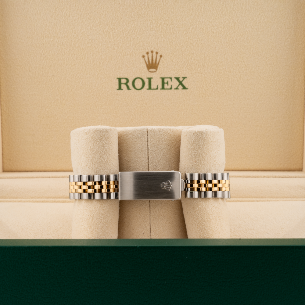 Rolex watch band on a cushioned display with Rolex logo in the background