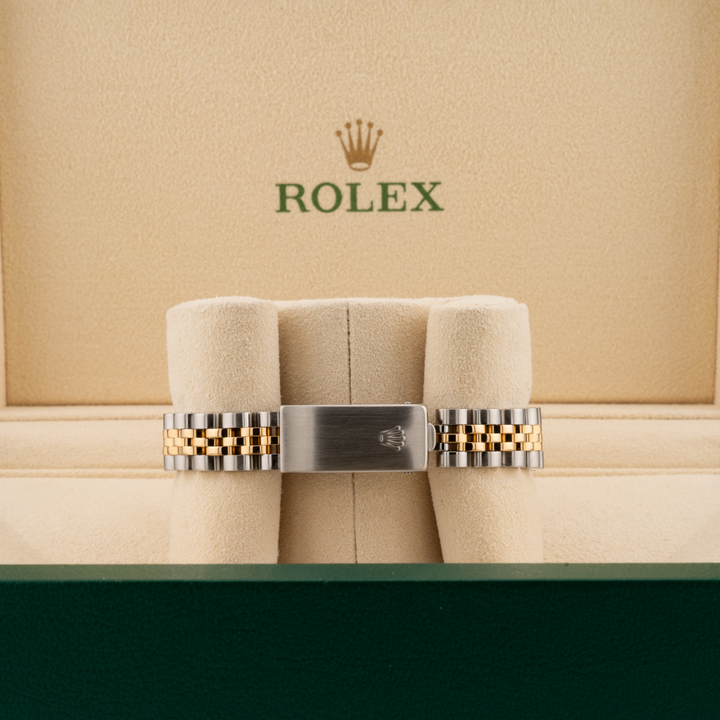 Rolex watch band on a cushioned display with Rolex logo in the background