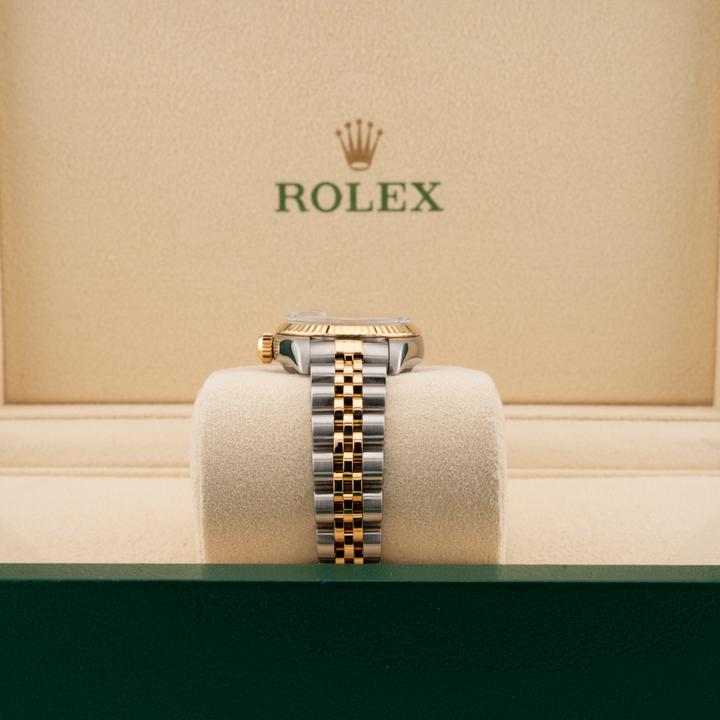 Rolex watch on a cushion with a beige background featuring the Rolex logo.