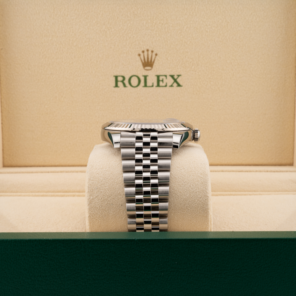 Silver Rolex watch on a display stand with a beige background featuring the Rolex logo.