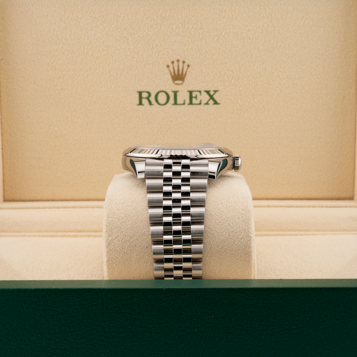 Silver Rolex watch on a display stand with a beige background featuring the Rolex logo.