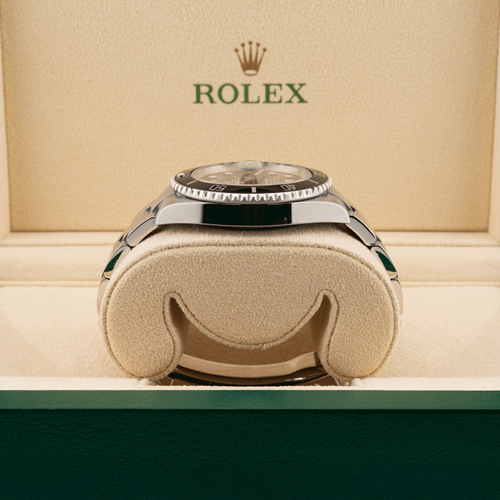 Rolex watch in a display case with the Rolex logo above