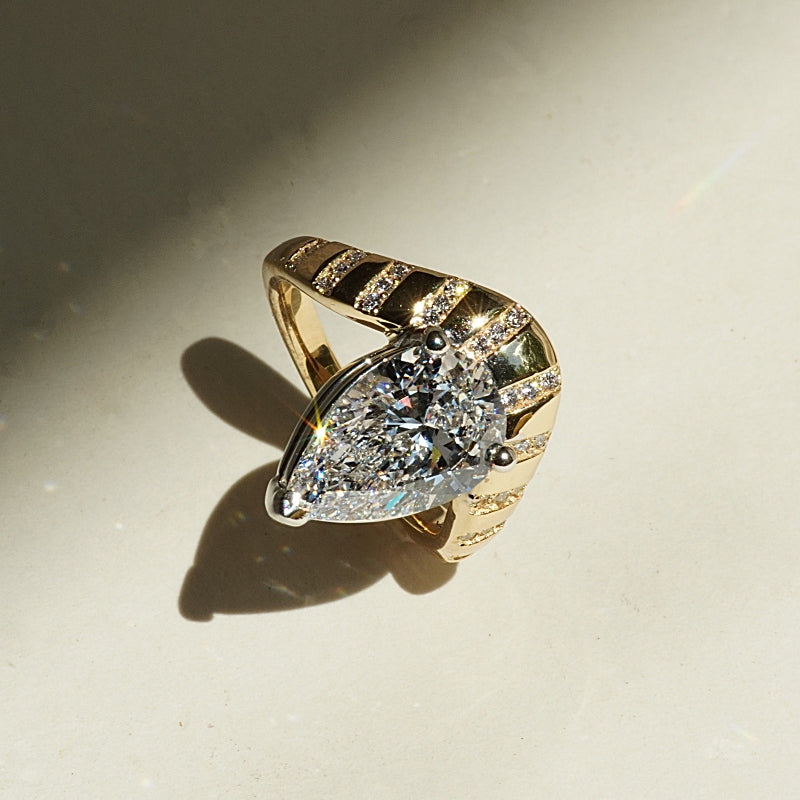 Pear Shape Diamond engagement ring on a contour cloud style setting with spaced out diamond stripes