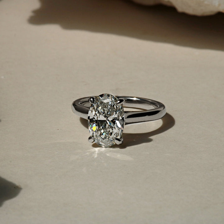 Oval solitaire cathedral engagement ring in white gold