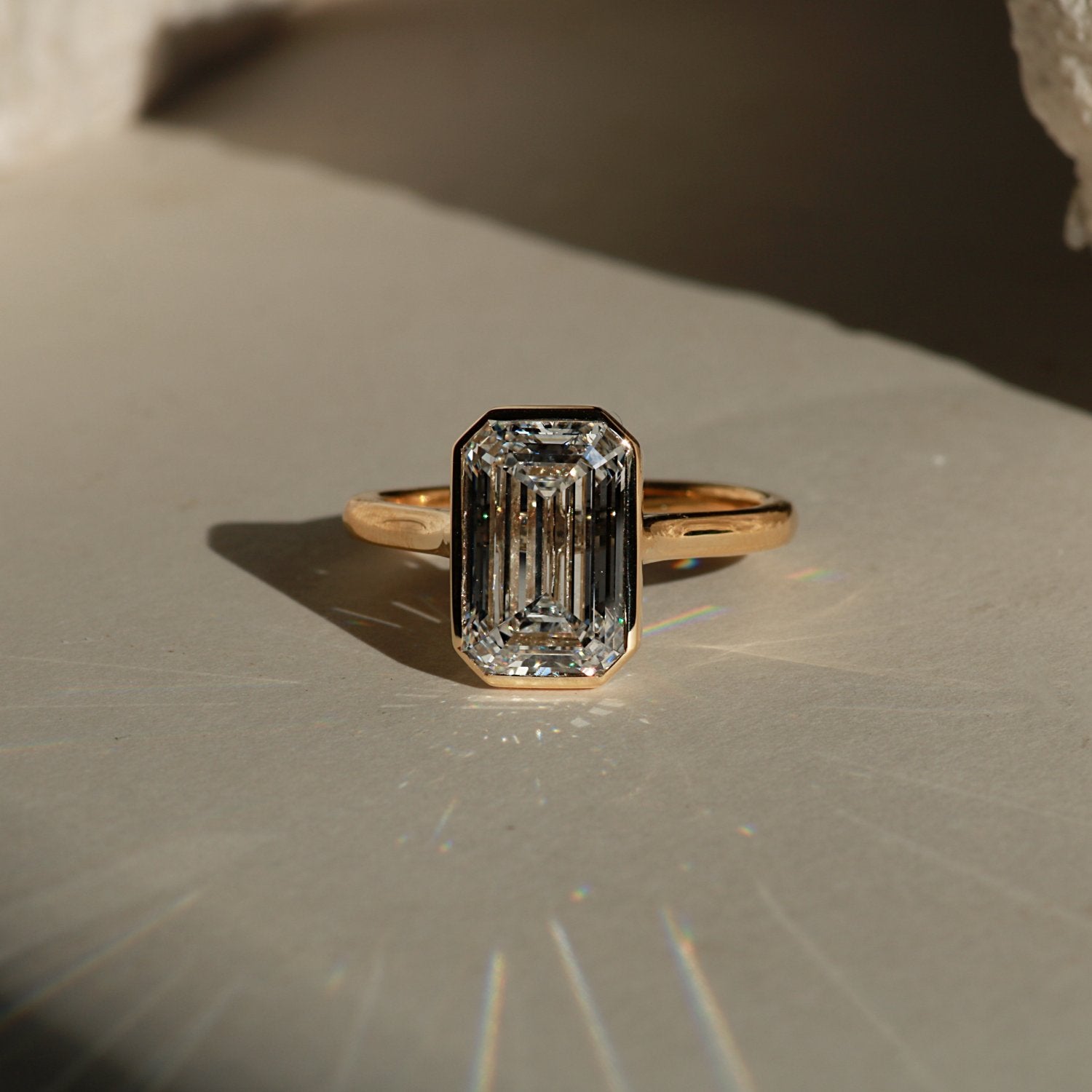 bezel set emerald cut engagement ring in yellow gold