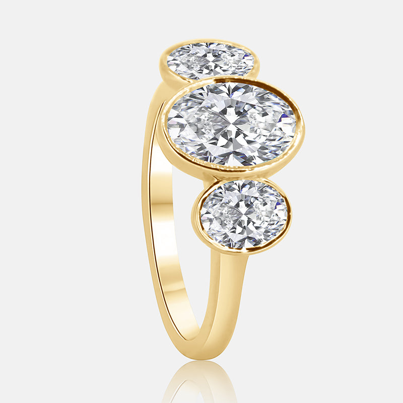 Three stone oval bezel diamond engagement ring in yellow gold