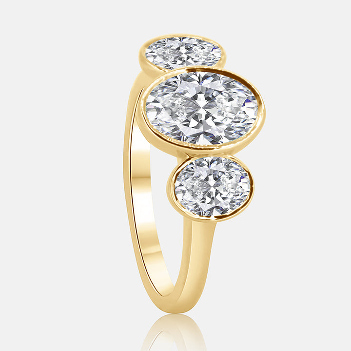Three stone oval bezel diamond engagement ring in yellow gold