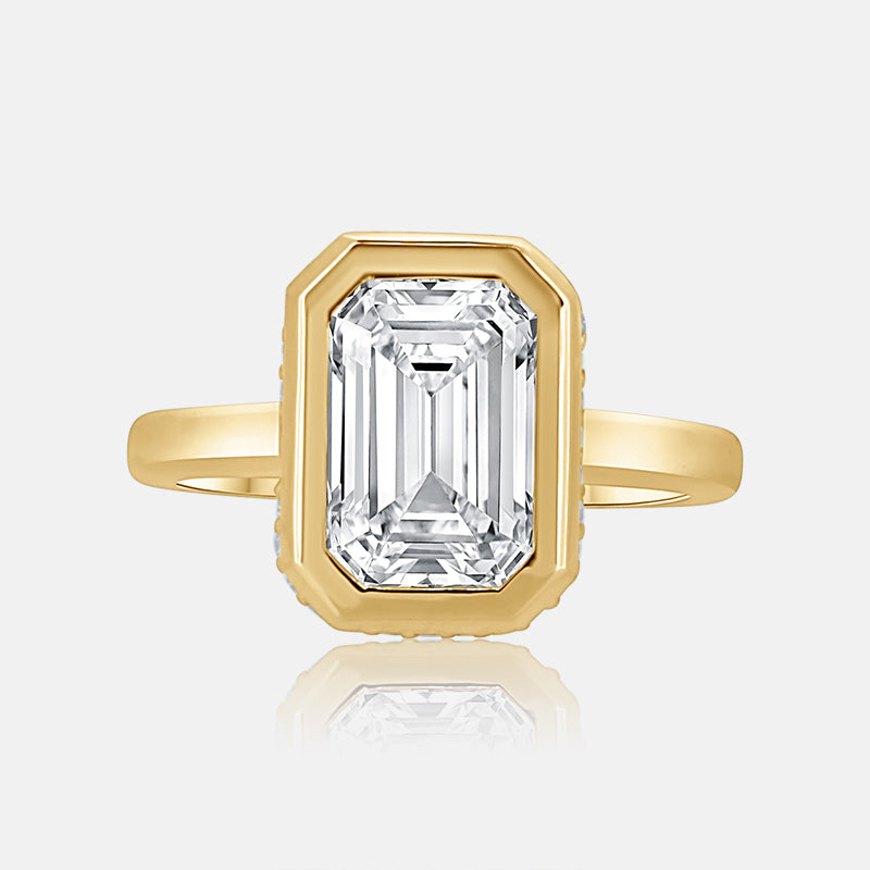 Emerald cut bezel set engagement ring with hidden halo