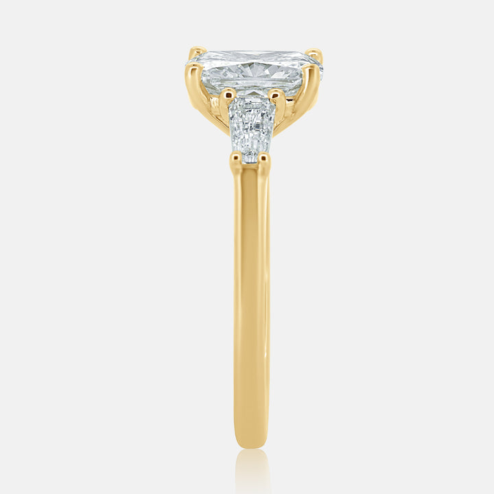 yellow gold three stone engagement ring with a cushion cut center diamond