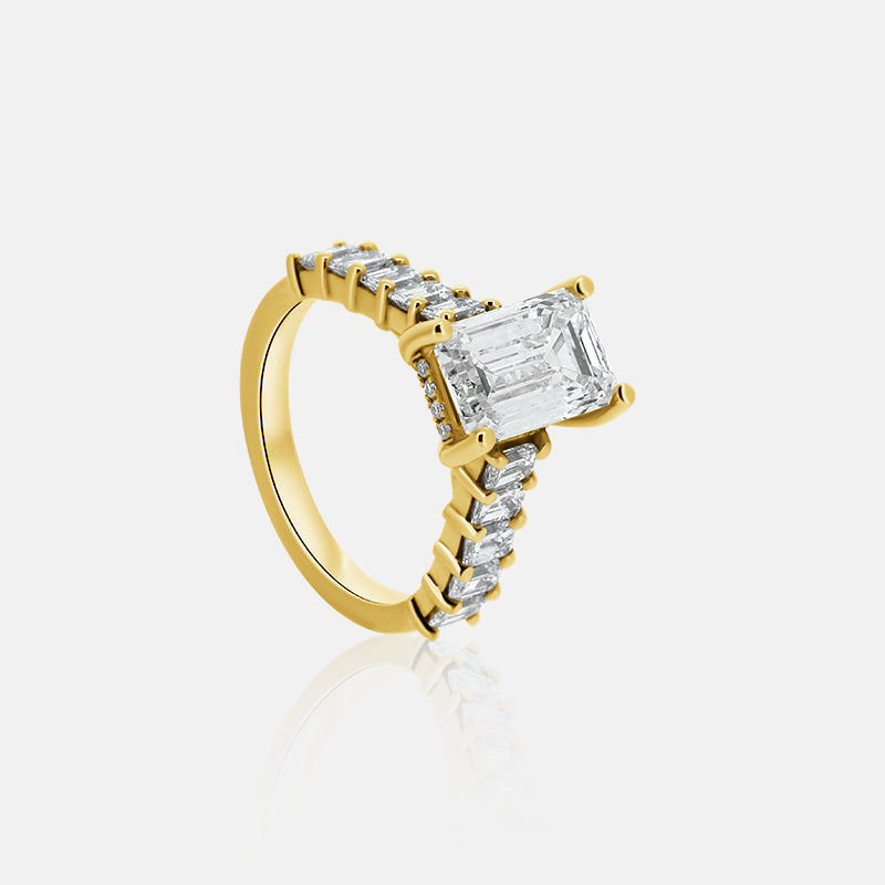 Emerald cut engagement ring with emerald cut side stones in yellow gold with a hidden halo