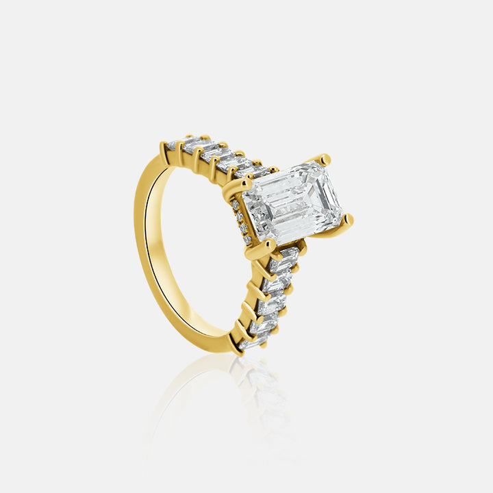 Emerald cut engagement ring with emerald cut side stones in yellow gold with a hidden halo