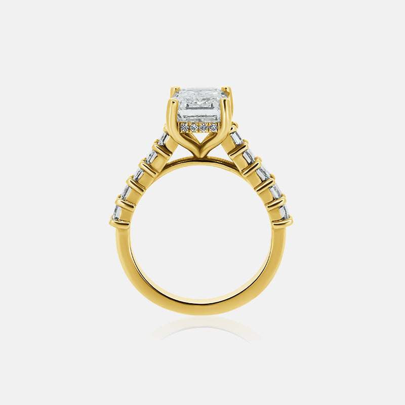 Emerald cut cathedral engagement ring with emerald cut side stones in yellow gold with a hidden halo