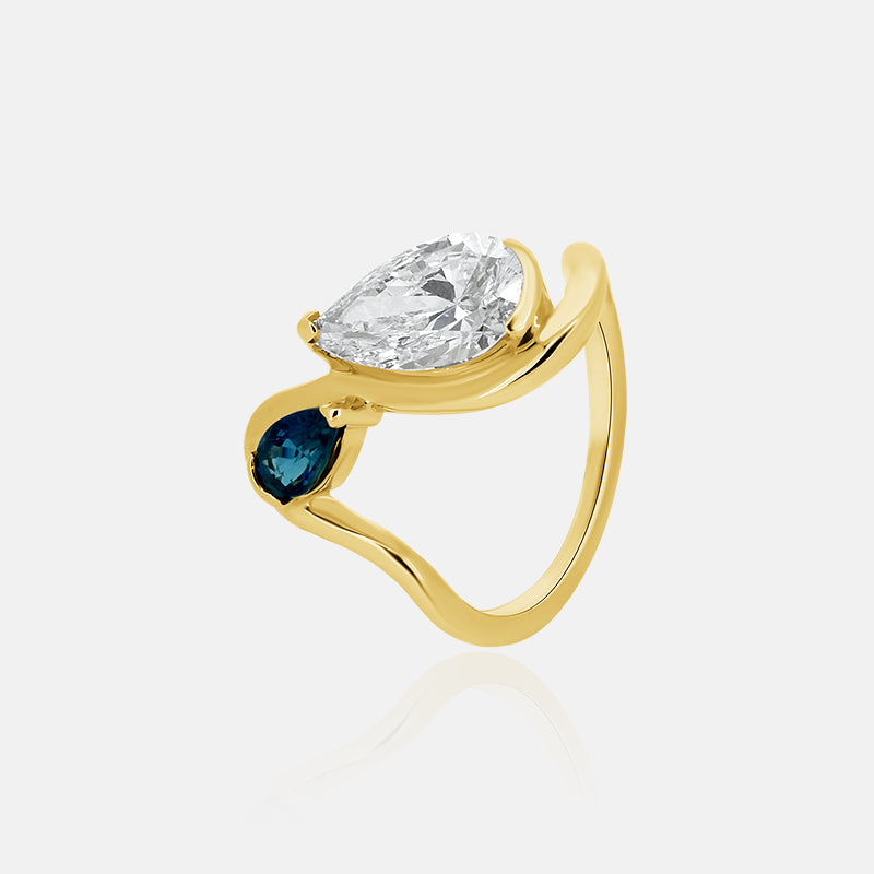 Pear shape wave engagement ring with a sapphire in yellow gold