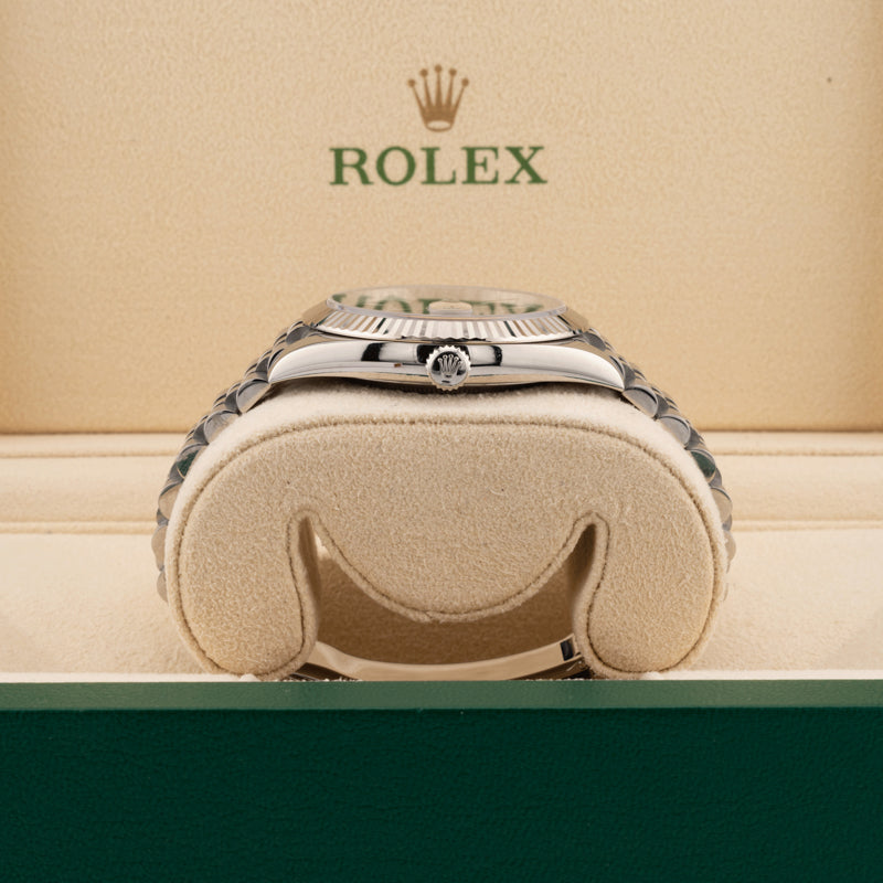 Rolex 126334 Blue Dial on a jubilee band displayed on it's side showing the winding crown in a beige rolex box 