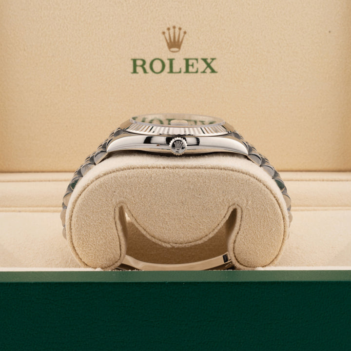 Rolex 126334 Blue Dial on a jubilee band displayed on it's side showing the winding crown in a beige rolex box 