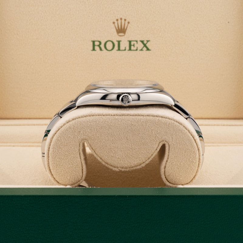 Rolex 124300 Green Dial Oyster perpetual  displayed on its side in a Rolex beige box  showing the winding crown 