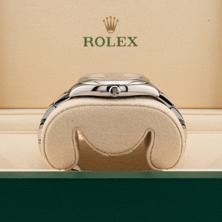 Rolex 124300 Green Dial Oyster perpetual  displayed on its side in a Rolex beige box  showing the winding crown 