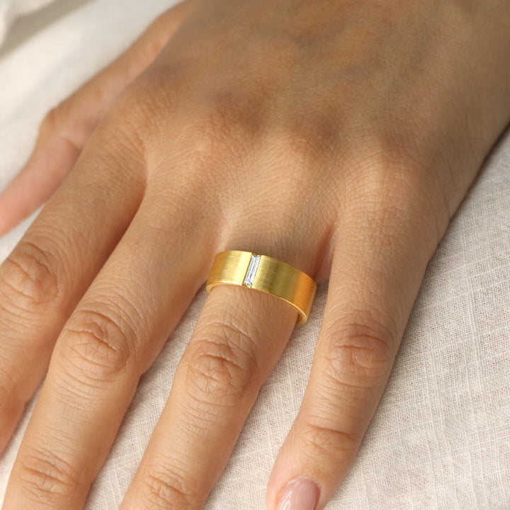 Modern Cigar Band in 14 Karat Yellow Gold with a .15 Carat Baguette Diamond